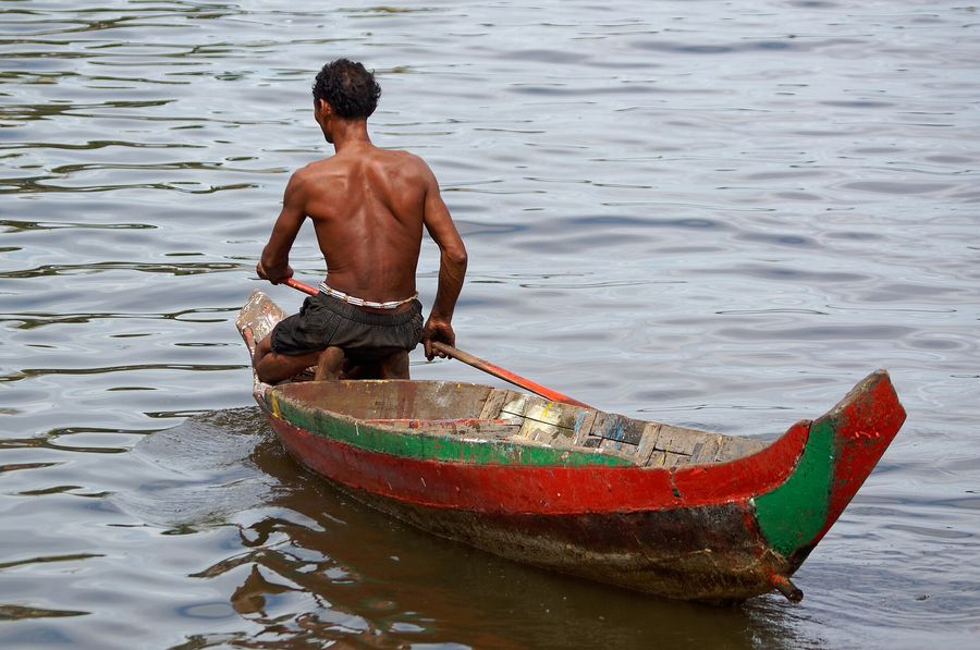 A fisherman standing in his boat on the Tonlé Sap